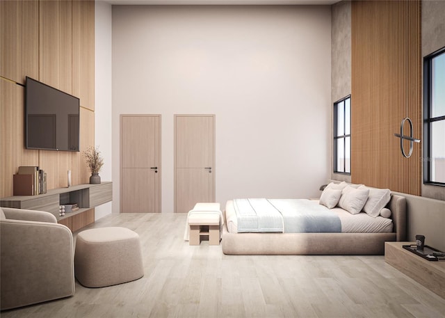 bedroom with a towering ceiling and hardwood / wood-style flooring