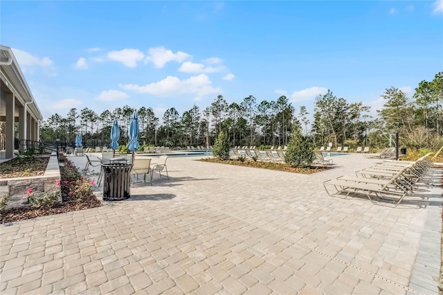 surrounding community with a swimming pool and a patio area