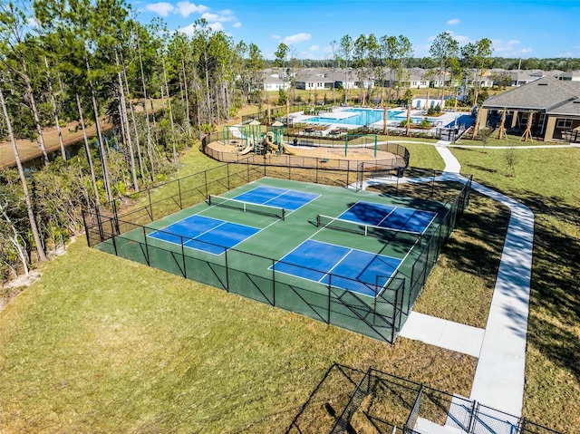 view of tennis court with a yard and a playground