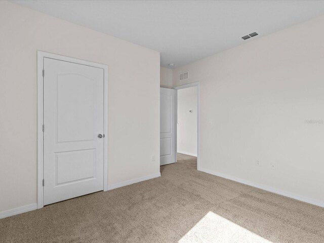 unfurnished bedroom featuring light carpet