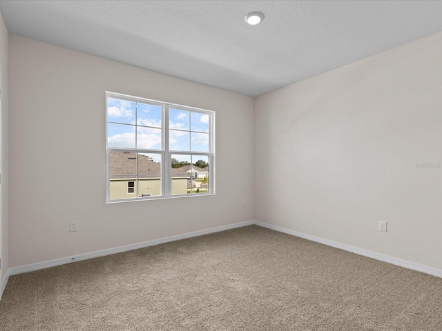 unfurnished room with carpet floors and a textured ceiling