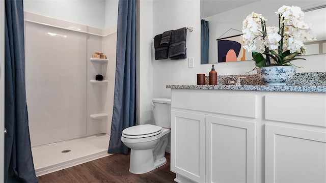 bathroom with vanity, toilet, wood-type flooring, and walk in shower