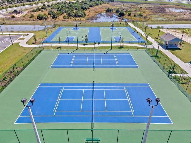 view of sport court featuring a lawn and basketball hoop