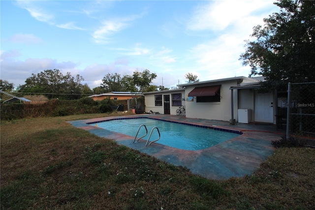 view of swimming pool with a yard