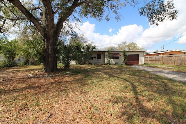 single story home featuring concrete driveway, a front lawn, an attached garage, and fence