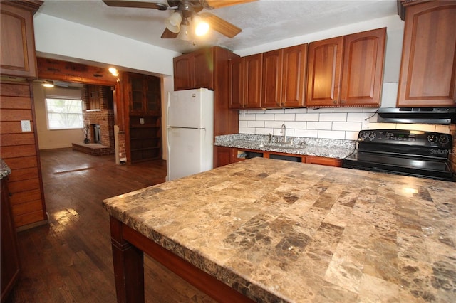 kitchen with tasteful backsplash, black electric range oven, freestanding refrigerator, a sink, and under cabinet range hood