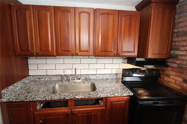 kitchen featuring tasteful backsplash, brick wall, range hood, black / electric stove, and a sink