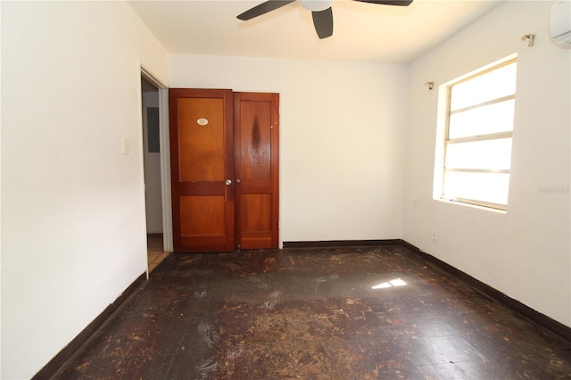 unfurnished room featuring an AC wall unit, ceiling fan, and baseboards