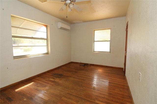 empty room featuring baseboards, a wall mounted air conditioner, and hardwood / wood-style floors