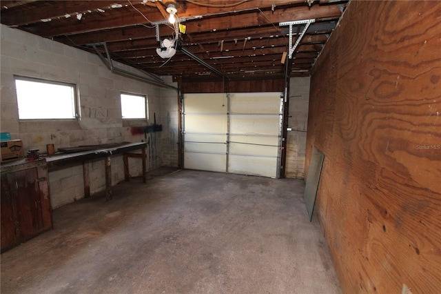 garage featuring concrete block wall and a garage door opener