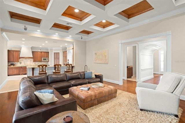 living room with beam ceiling, coffered ceiling, and ornamental molding