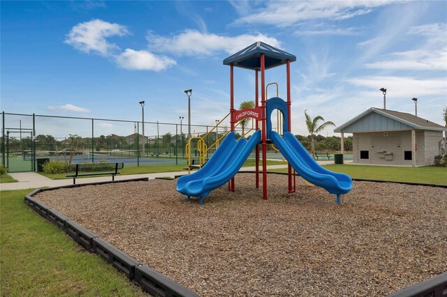 view of jungle gym featuring tennis court