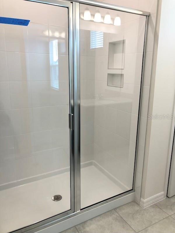 bathroom with tile patterned floors and an enclosed shower