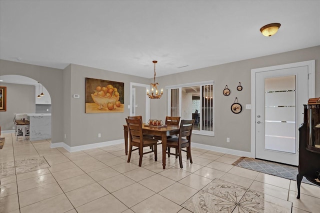 dining area with light tile patterned floors and an inviting chandelier