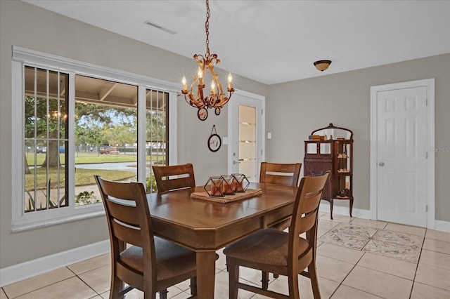 tiled dining room with an inviting chandelier