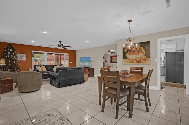 dining room with ceiling fan with notable chandelier and light tile patterned flooring