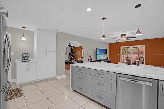 kitchen featuring light stone countertops, ceiling fan, light tile patterned floors, and stainless steel appliances