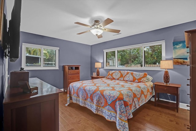 bedroom featuring multiple windows, light hardwood / wood-style floors, and ceiling fan