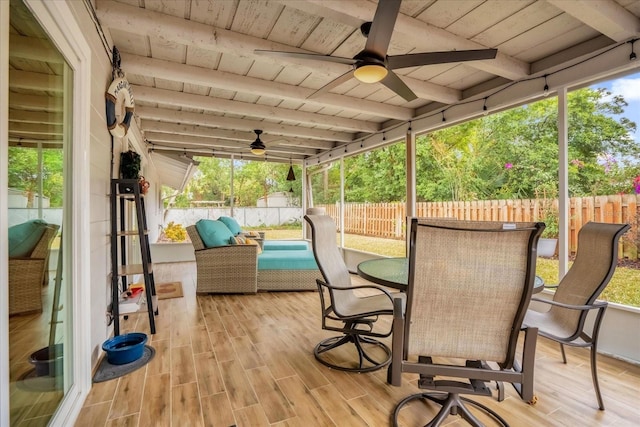 sunroom with beamed ceiling, ceiling fan, and wooden ceiling