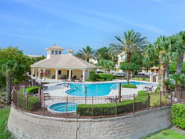 view of swimming pool featuring a hot tub and a patio