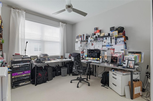 carpeted office space featuring ceiling fan