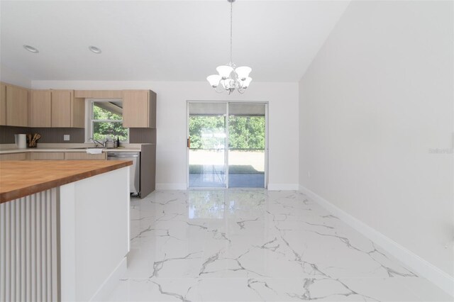 kitchen with wood counters, stainless steel dishwasher, a notable chandelier, lofted ceiling, and decorative light fixtures