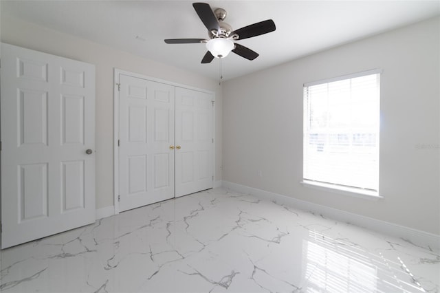 unfurnished bedroom featuring ceiling fan and a closet