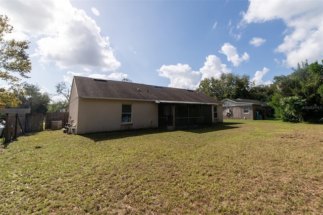 rear view of house with a sunroom and a yard