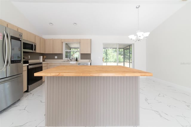 kitchen featuring a kitchen island, butcher block counters, light brown cabinetry, and appliances with stainless steel finishes