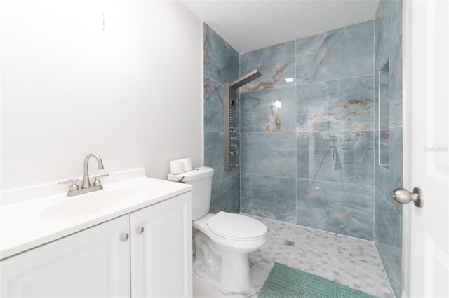 bathroom featuring vanity, toilet, and tiled shower