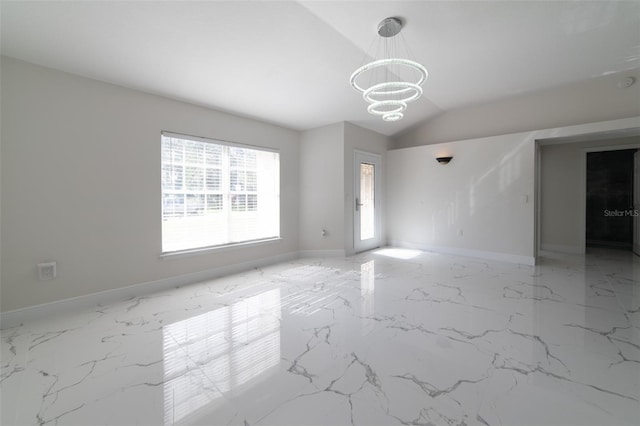 spare room featuring a chandelier and vaulted ceiling