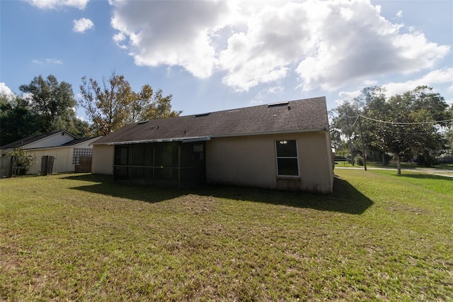 back of property with a sunroom and a yard