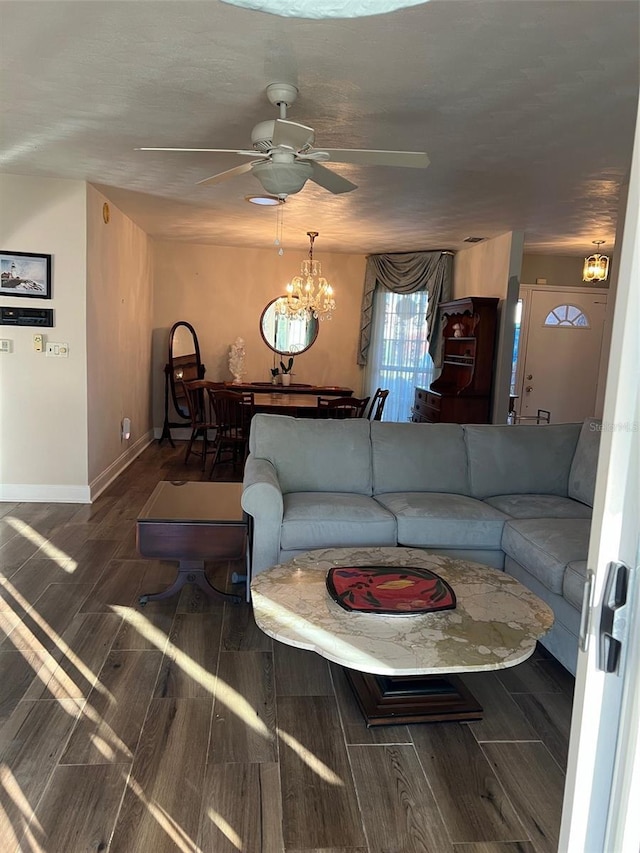 living room featuring ceiling fan with notable chandelier and dark hardwood / wood-style flooring