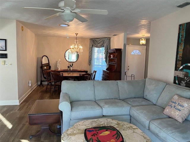 living room featuring dark wood-type flooring and ceiling fan with notable chandelier