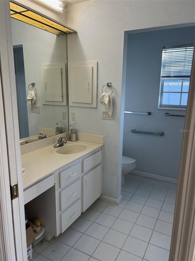 bathroom featuring tile patterned flooring, vanity, and toilet