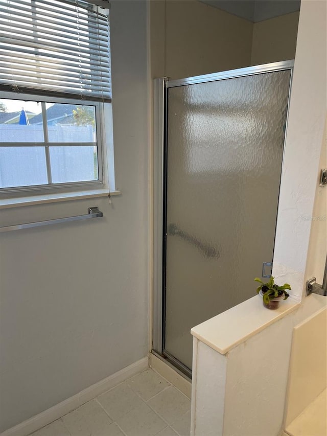 bathroom featuring tile patterned flooring and an enclosed shower