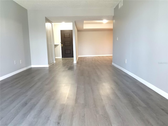 empty room featuring a textured ceiling and dark wood-type flooring