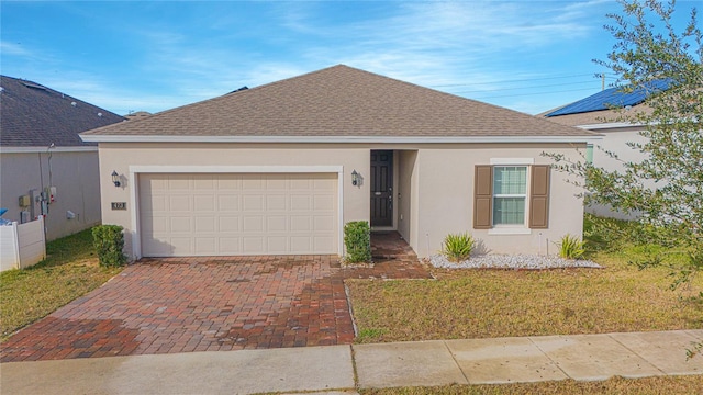 single story home featuring a garage and a front lawn