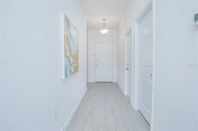 corridor with light hardwood / wood-style flooring