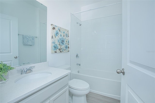 full bathroom with tiled shower / bath, toilet, vanity, and hardwood / wood-style flooring