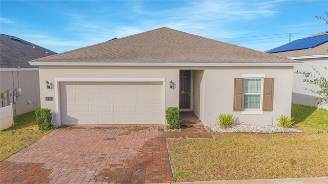 single story home featuring stucco siding, decorative driveway, an attached garage, and a shingled roof