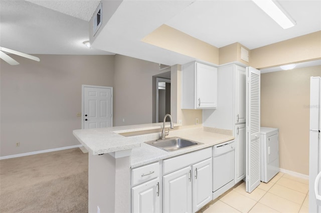 kitchen featuring sink, kitchen peninsula, washer / clothes dryer, white dishwasher, and light carpet