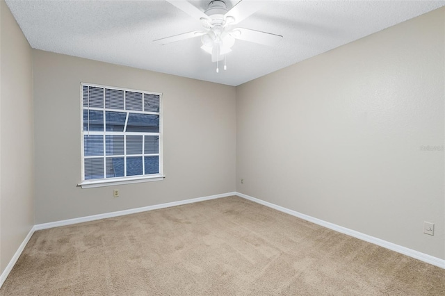 carpeted empty room with ceiling fan and a textured ceiling