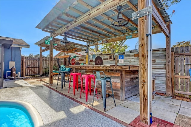 view of patio featuring an outdoor bar and a pool