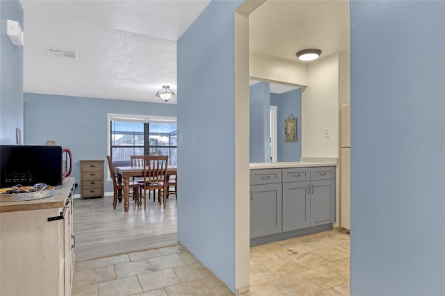 hallway featuring a textured ceiling and light wood-type flooring