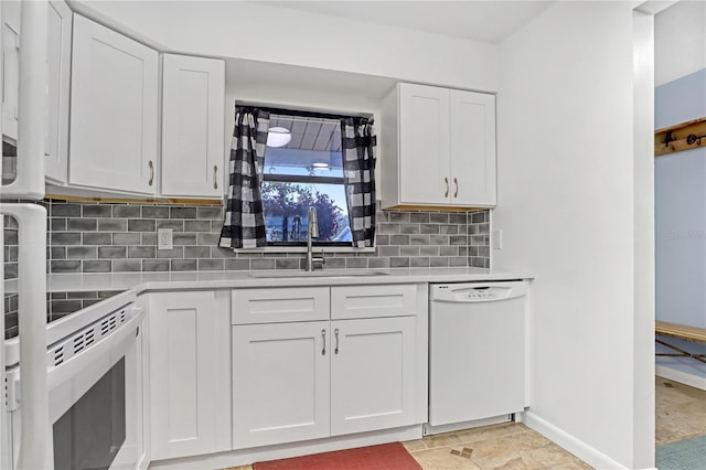 kitchen with white appliances, sink, white cabinetry, light tile patterned flooring, and tasteful backsplash