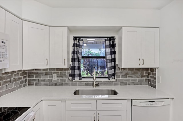 kitchen featuring sink, white dishwasher, white cabinets, and decorative backsplash