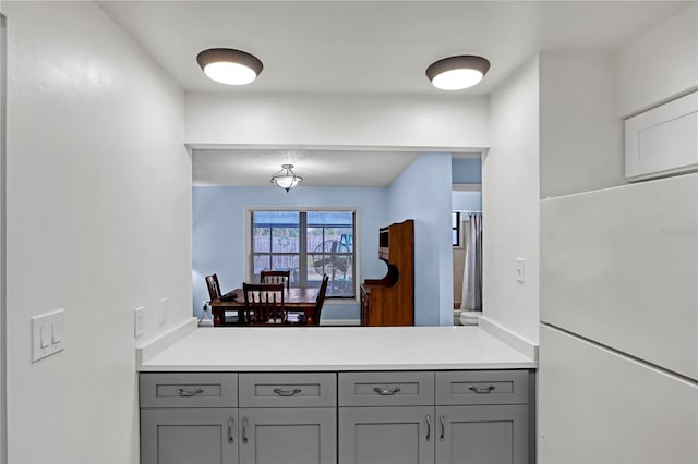 kitchen with white refrigerator and gray cabinets