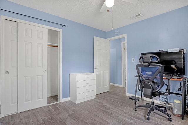 home office with a textured ceiling and ceiling fan