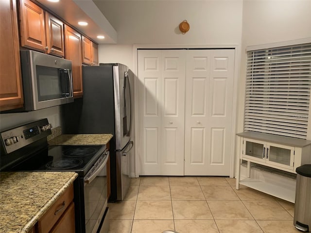 kitchen featuring light stone countertops, light tile patterned floors, and appliances with stainless steel finishes